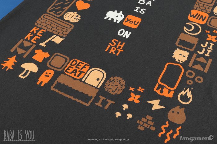 A closeup of the bottom of the Baba Is Shirt t-shirt. Here the frame features words like WIN, KEKE, and DEFEAT as well as several characters and items like a jack-o-lantern and a door.
