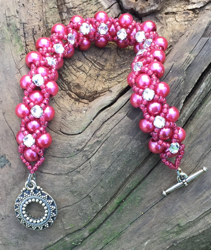 This Dark Rose glass pearl bracelet is netted with Rose colored seed beads and topped with Swarovski Crystal AB Montees. This bracelet measures 7 7/8".