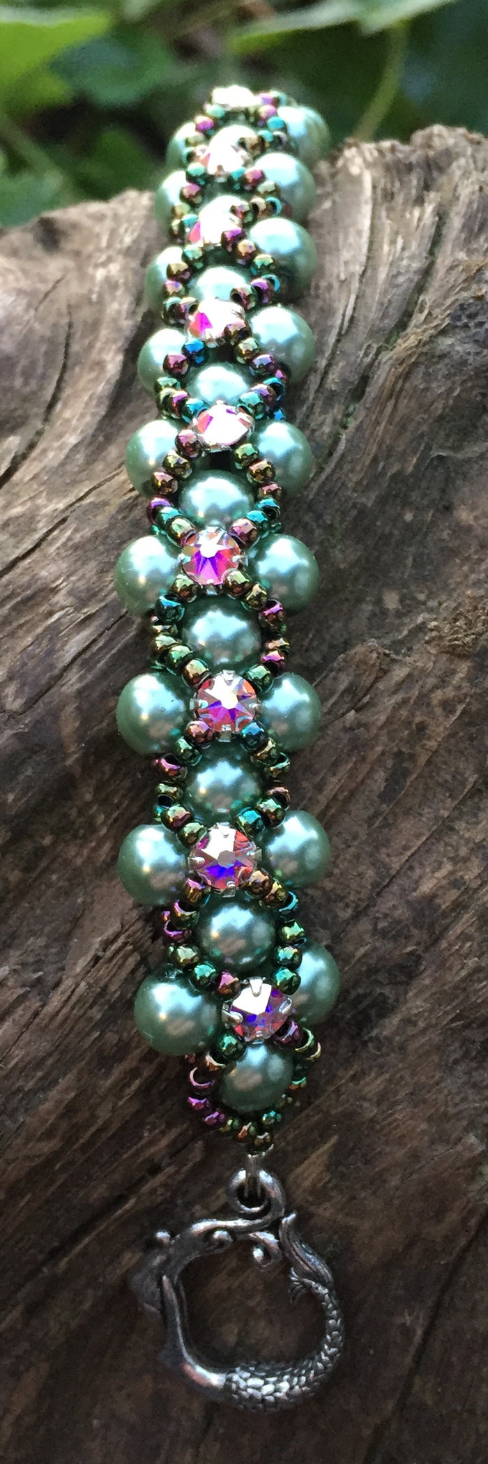 This Sage colored pearl bracelet is entwined with Metallic Iris Seed beads and Swarovski Crystal Montees and measures 7 1/2".