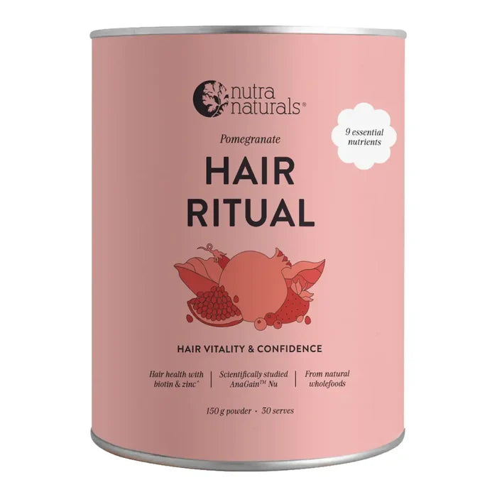 A pink cylindrical tin of Nutra Naturals Hair Ritual powder, featuring a pomegranate illustration on the label, set against a plain white background.