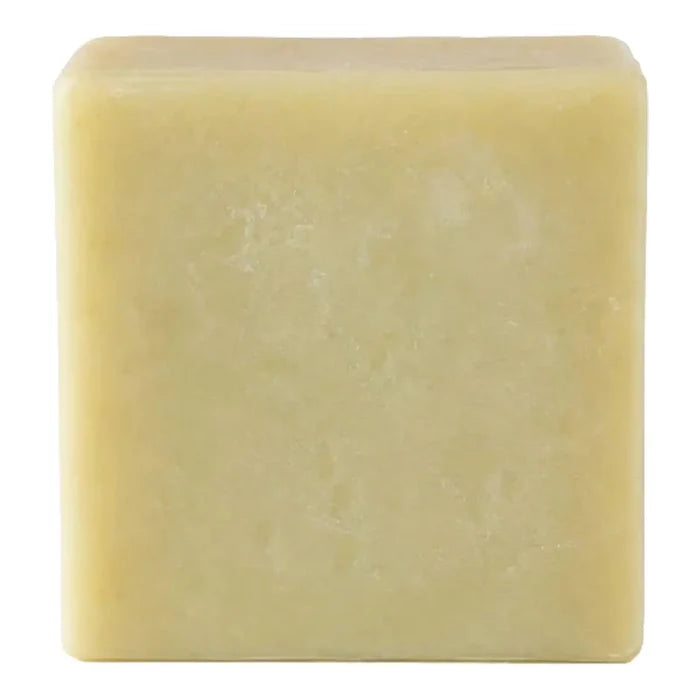 A single square bar of pale yellow soap with a textured surface, isolated on a white background.