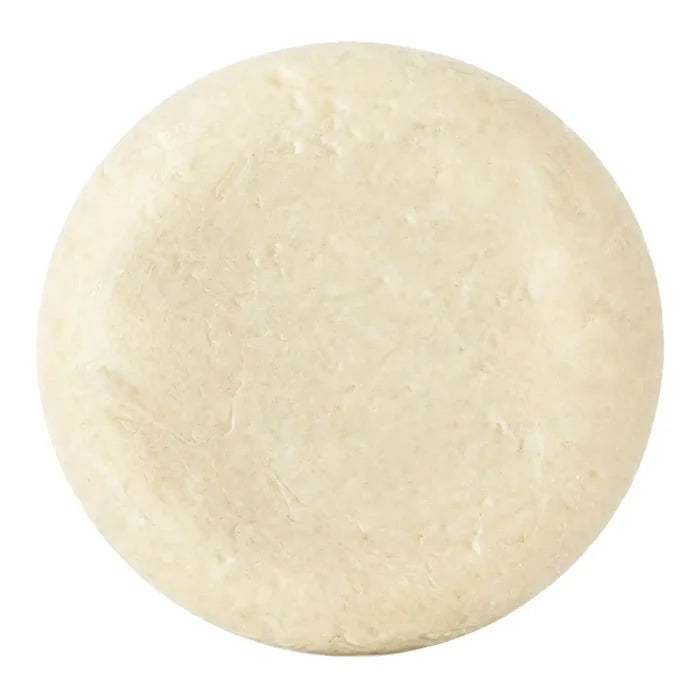 A round, textured bar of soap in an off-white colour, shown from a top-down view on a solid white background.
