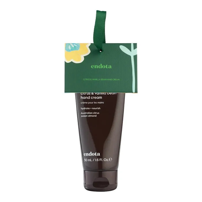 Endota Citrus & Vanilla Hand Cream in a dark brown squeeze tube with a green hanging tag, shown on a plain white background.